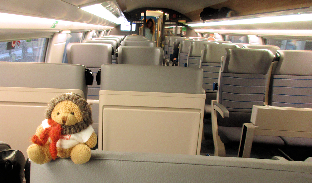 Little Bear sitting on seat of the Thalys high-speed electric train flying through France!