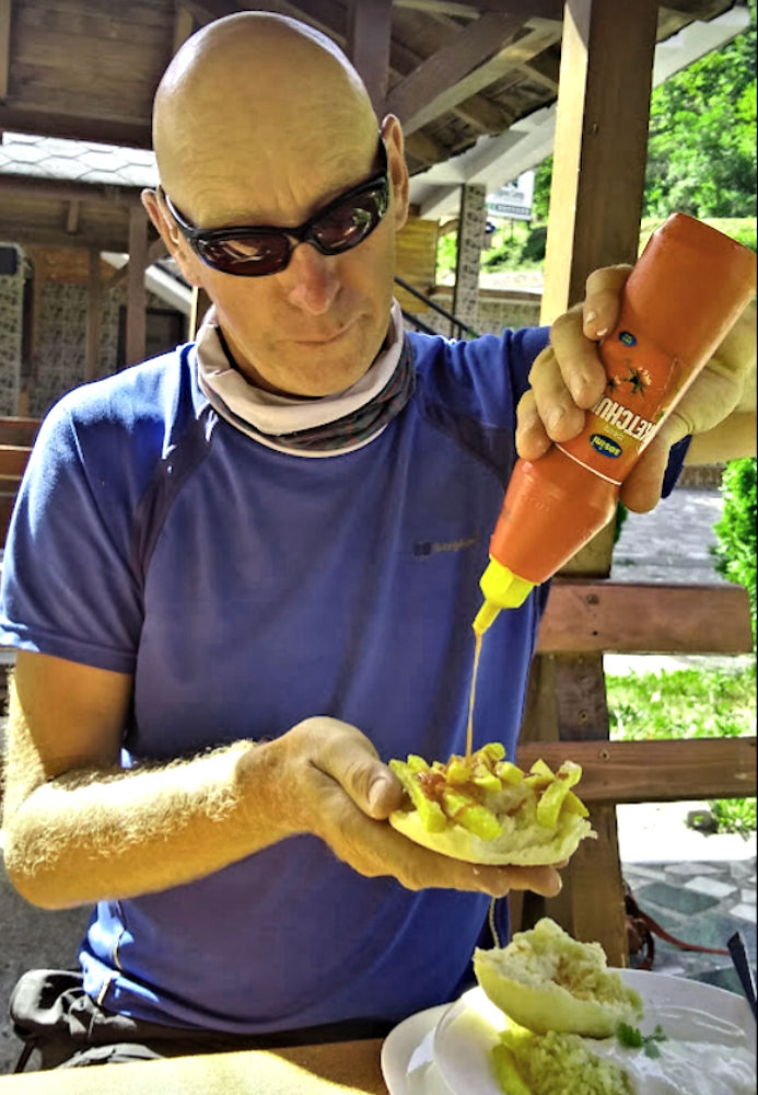 Nev preparing his french fries sandwich with catsup