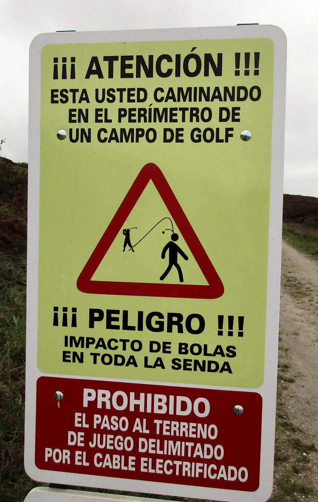 Sign next to golf course warning of flying balls