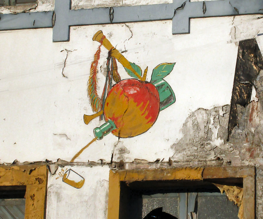 Mural on the side of an abandoned cidery depicting a bagpipe pouring cider