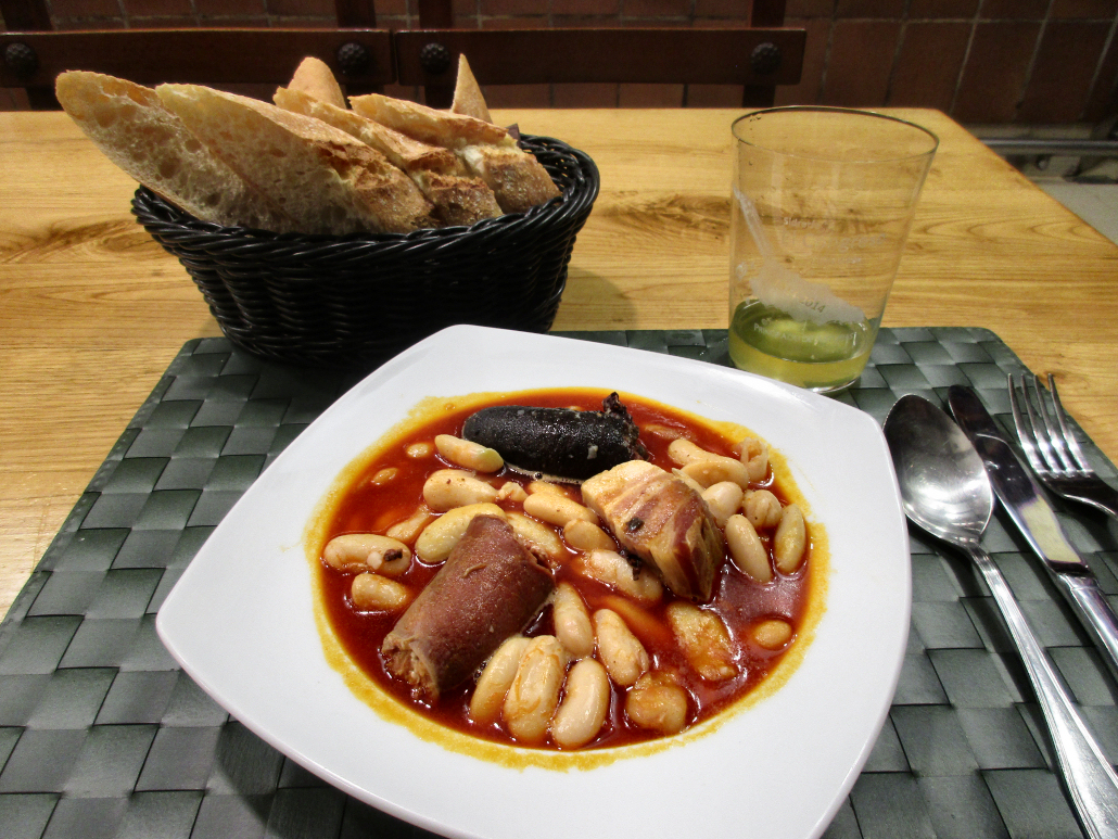 A dish of fabada with apple cider