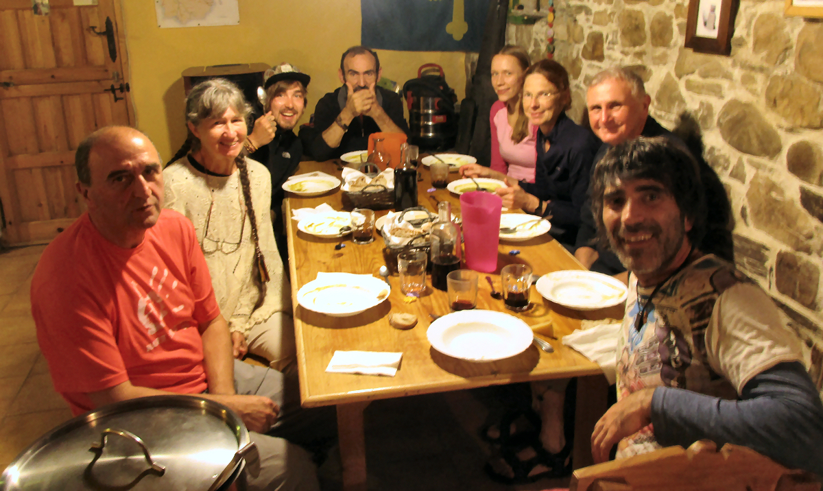 Pilgrims and hosts eating dinner together at Albergue de Bodenaya