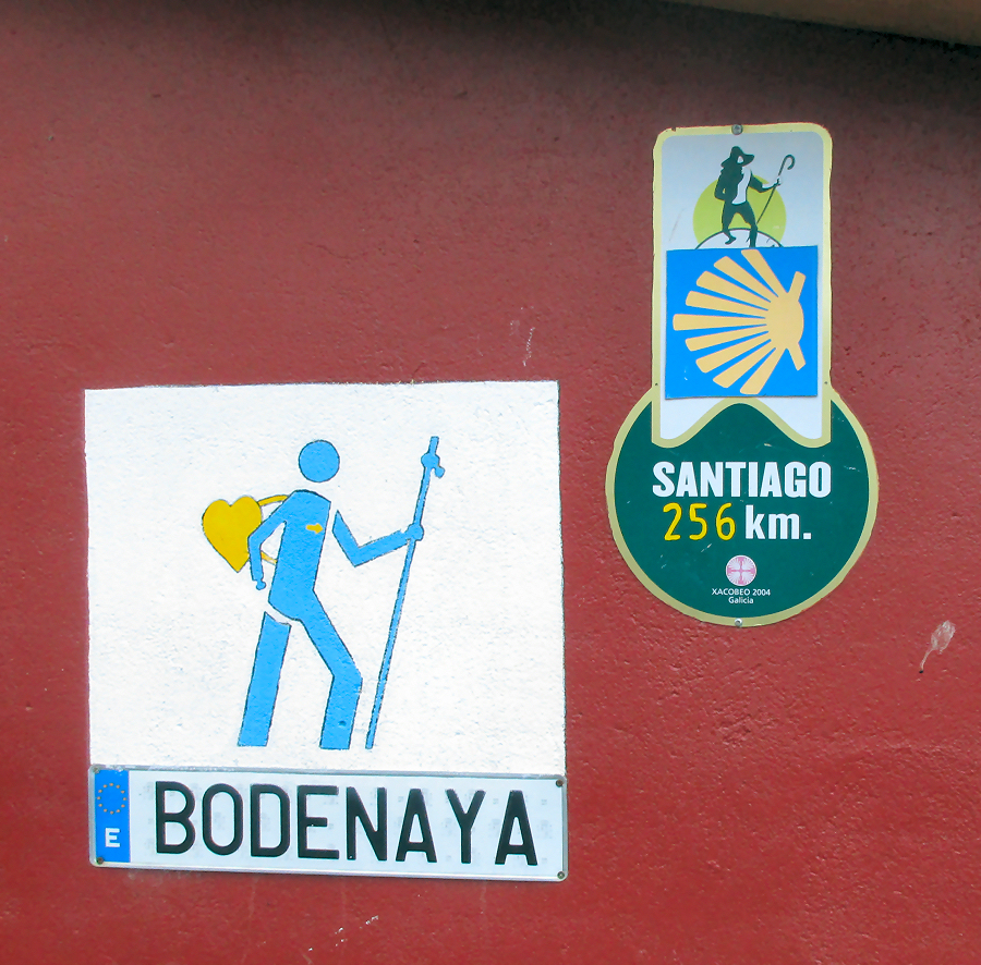 Pilgrim images on the front of Albergue de Bodenaya, along with a sign showing that it is 256 kilometers to Santiago