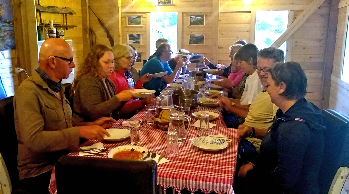 Group of trekker sitting around the dinner table at Guesthouse Lojza