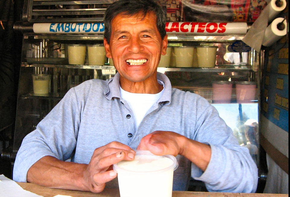 Man packing yogurt at a roadside stand in Peru