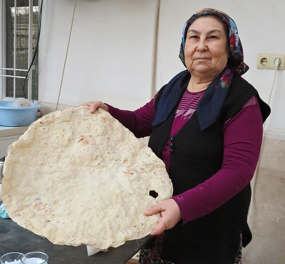Turkish woman showing one of her huge borek flatbread
