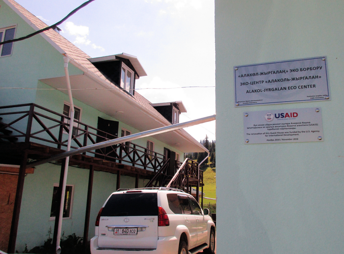 The side of a guesthouse in Jyrgalan with a USAID sign on the wall